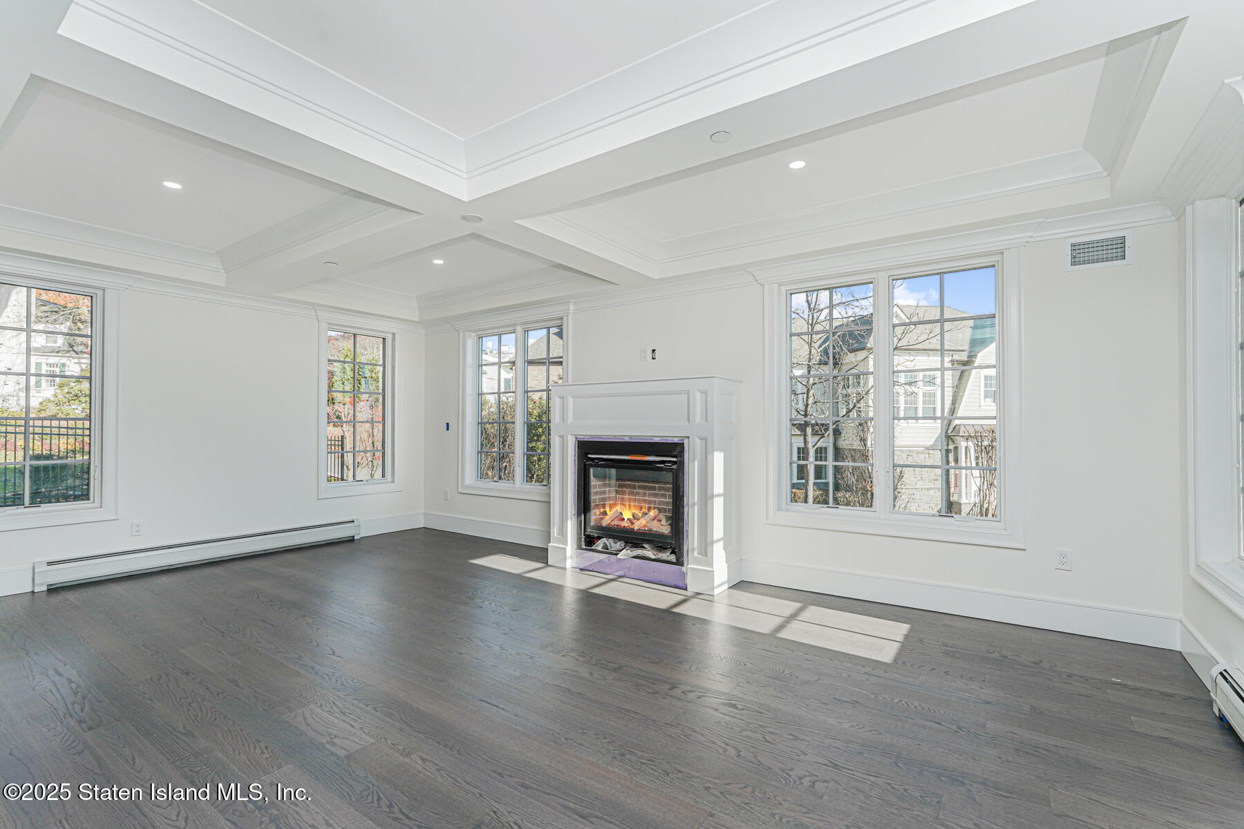 91 West Entry Road Staten Island, NY 10304 - Photo 11 of 57 an empty room with wooden floor fireplace and windows