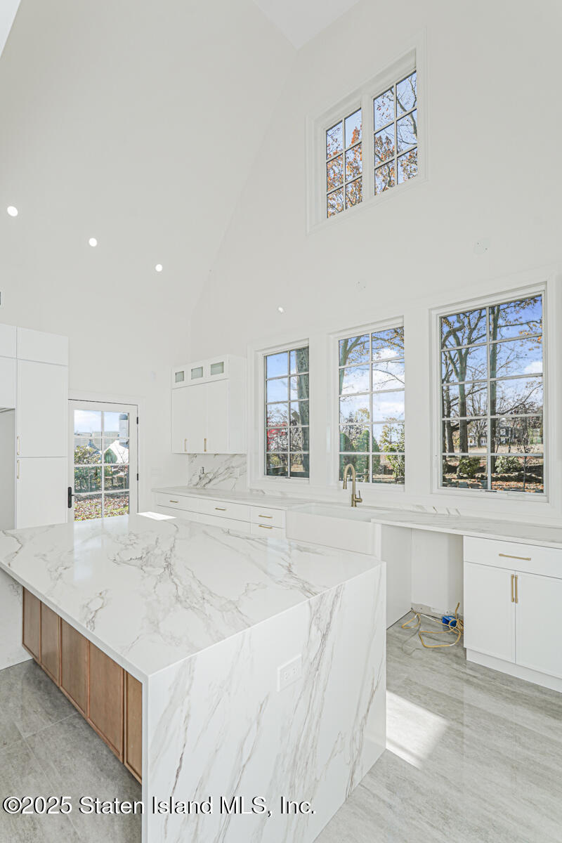 91 West Entry Road Staten Island, NY 10304 - Photo 27 of 57 a spacious bathroom with a granite countertop sink a large mirror and a bathtub
