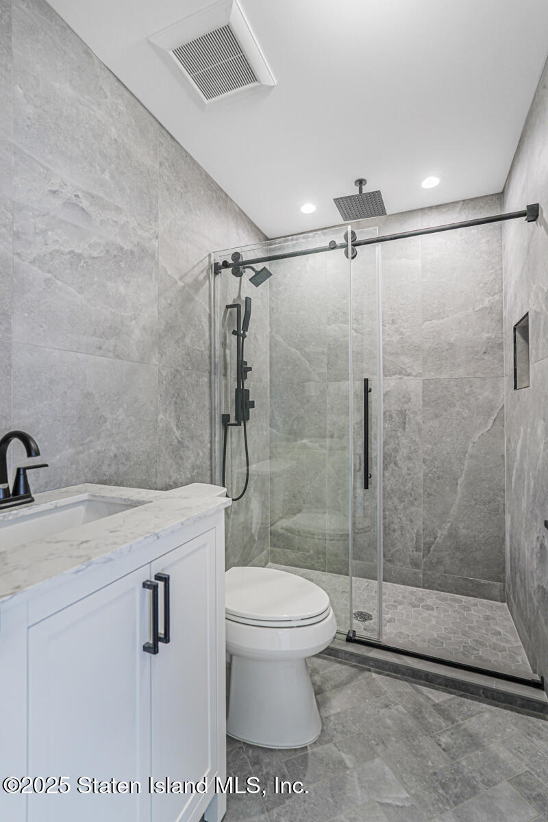 91 West Entry Road Staten Island, NY 10304 - Photo 46 of 57 a bathroom with a shower a toilet and a sink