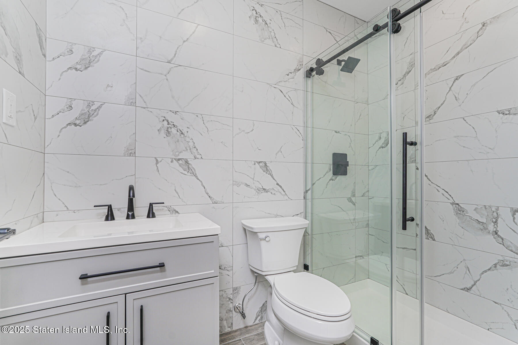 91 West Entry Road Staten Island, NY 10304 - Photo 48 of 57 a bathroom with a sink a toilet and shower