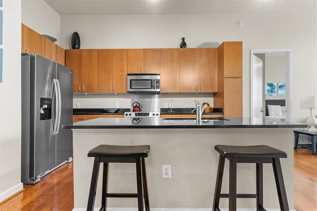 a kitchen with stainless steel appliances a sink cabinets and a refrigerator