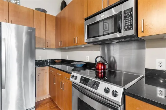 a kitchen with stainless steel appliances granite countertop a stove and a refrigerator