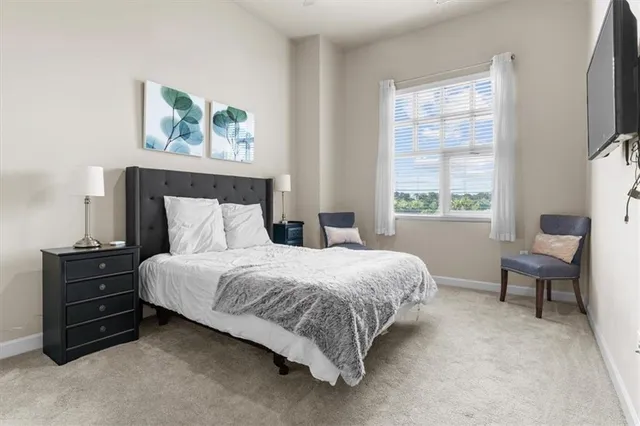 a bedroom with a bed dresser and a window