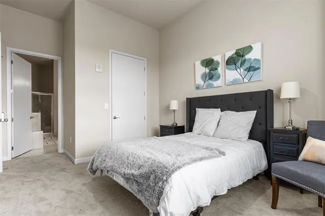 a bedroom with a bed a couch and a painting on the wall