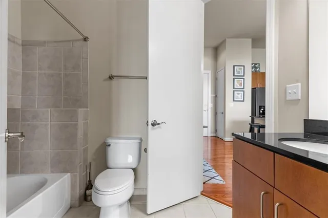 a bathroom with a granite countertop toilet a sink and bathtub
