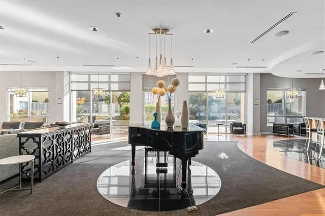 a living room with furniture large windows and wooden floor