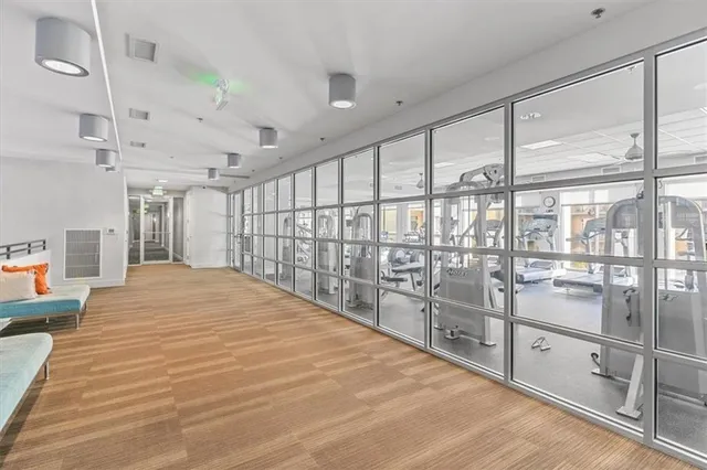a large white room with kitchen view and wooden floor