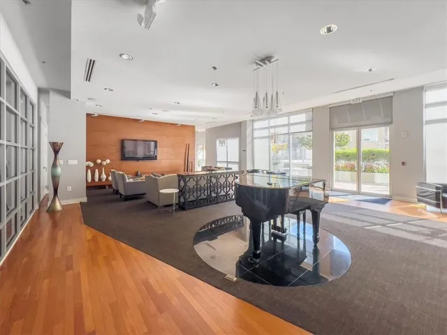 a living room with furniture large window and wooden floor