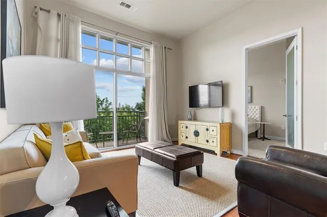 a living room with furniture a large window and a flat screen tv