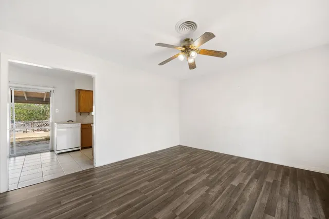 a view of empty room with wooden floor and window