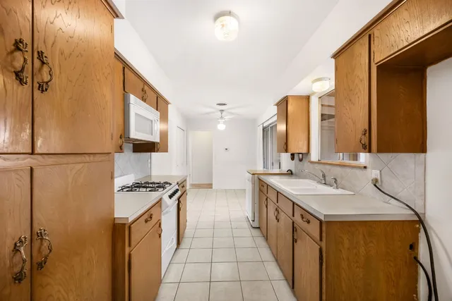 a large kitchen with stainless steel appliances a sink stove and cabinets