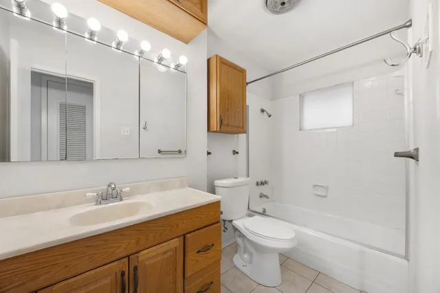 a bathroom with a granite countertop sink a toilet and shower