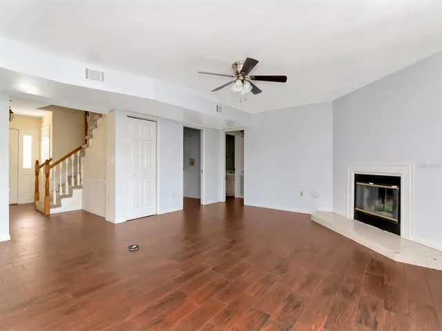 a view of empty room with wooden floor and fireplace