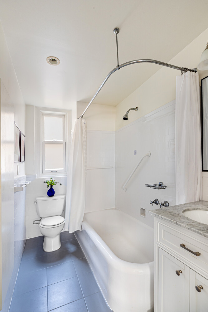 111 East 75th Street, Unit 7C Manhattan, NY 10021 - Photo 5 of 7 a bathroom with a sink a toilet and shower