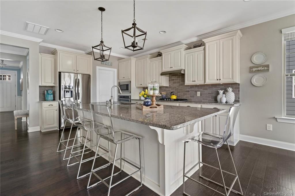 274 Helton Lane Fort Mill, SC 29708 - Photo 22 of 44 a kitchen with kitchen island granite countertop a table chairs cabinets and wooden floor