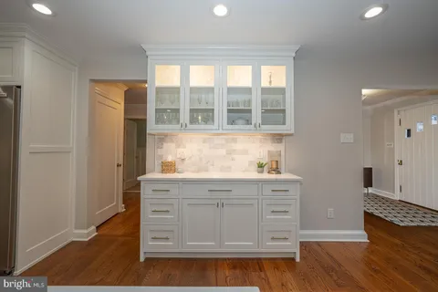 a kitchen with granite countertop a sink cabinets and wooden floor