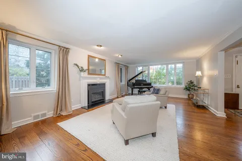 a living room with fireplace furniture and a large window