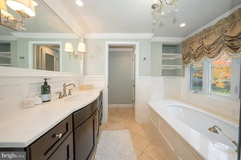 a spacious bathroom with a granite countertop sink a bathtub and a mirror