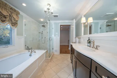a spacious bathroom with a bathtub shower sink double and mirror