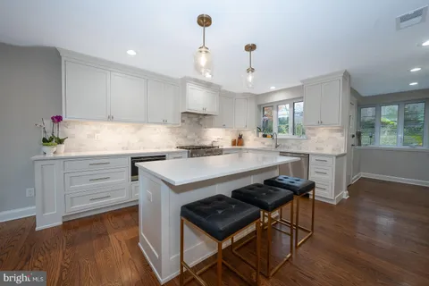 a kitchen with a table chairs refrigerator and cabinets