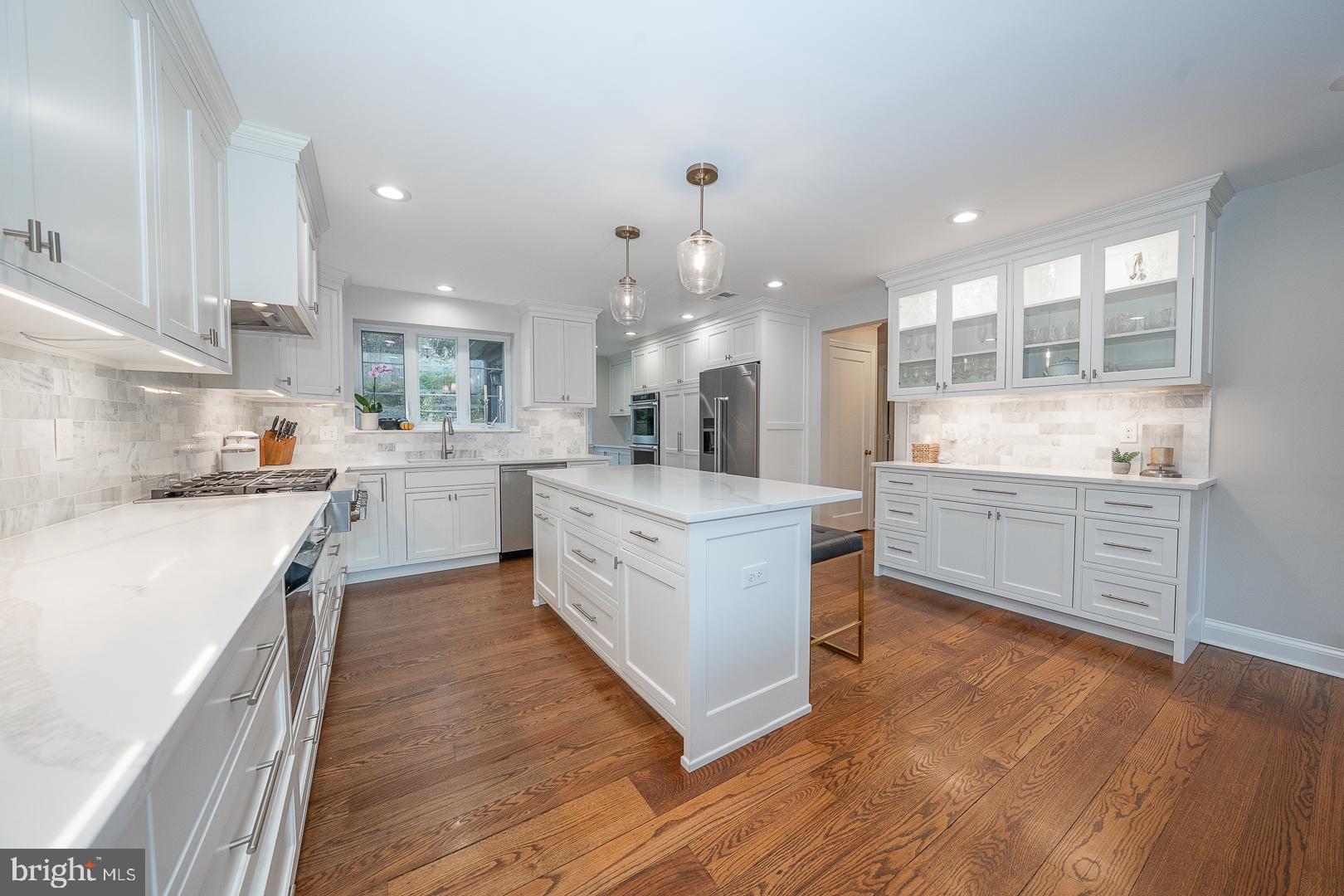 346 Winding Way Merion Station, PA 19066 - Photo 7 of 51 a kitchen with stainless steel appliances kitchen island wooden floors and white cabinets