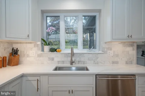 a kitchen with stainless steel appliances a sink a window and cabinets