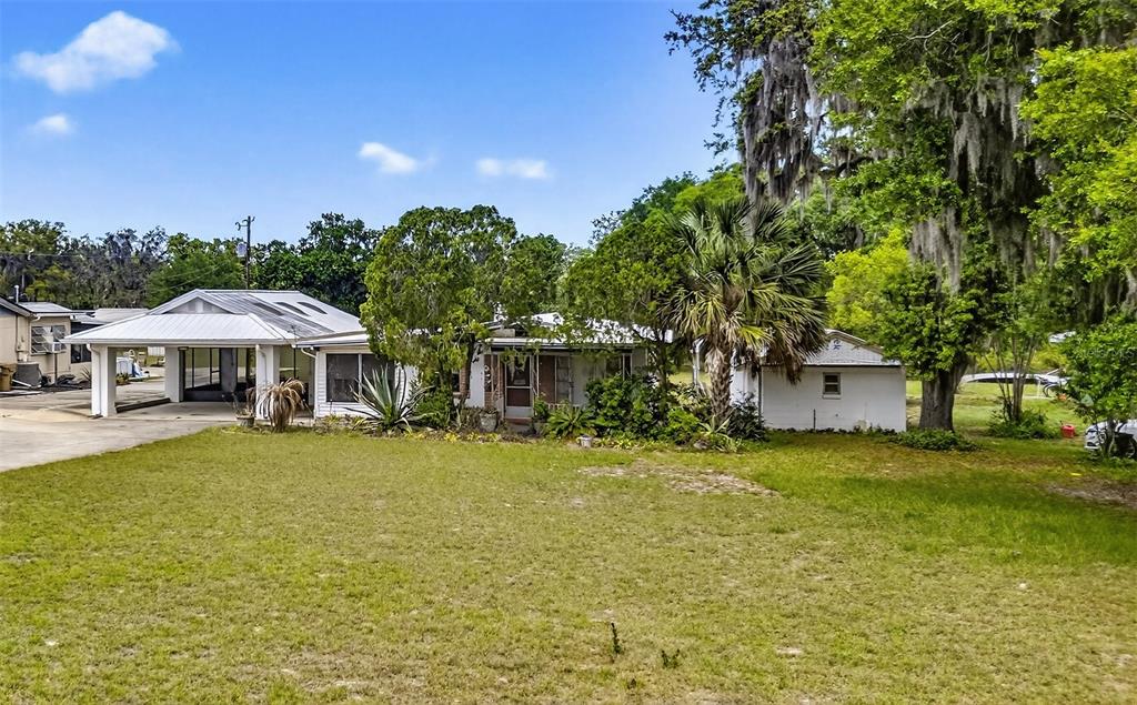34618 South Haines Creek Road Leesburg, FL 34788 - Photo 10 of 41 a view of a house with pool and chairs under an umbrella