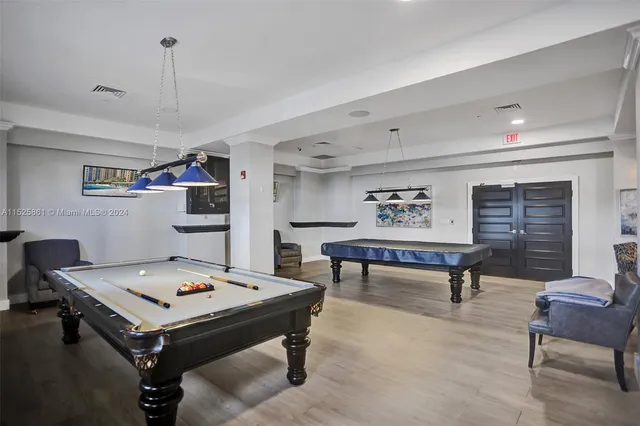 a room with furniture pool table and window