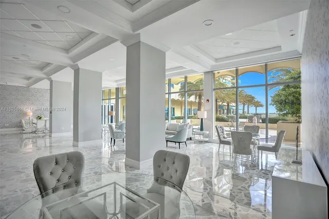 a dining room with furniture large windows and wooden floor
