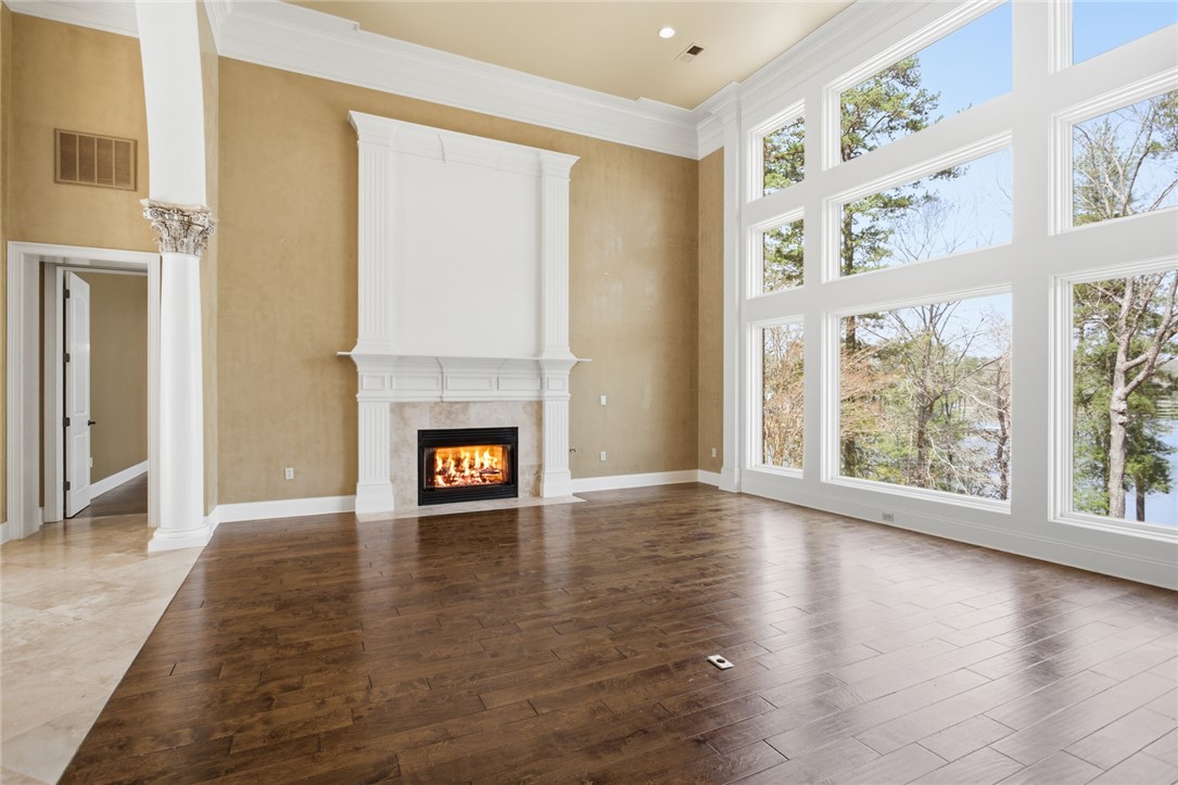 610 Highridge Drive Seneca, SC 29672 - Photo 9 of 50 This airy living room features expansive windows, a warm fireplace, and rich hardwood flooring.