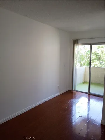 an empty room with wooden floor and door