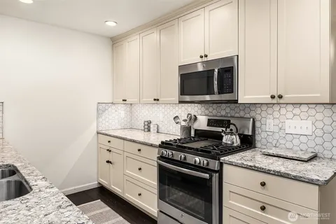 a kitchen with stainless steel appliances microwave stove refrigerator and cabinets