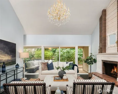 a living room with furniture a chandelier and a fireplace