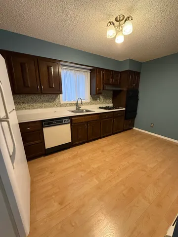 a kitchen with stainless steel appliances granite countertop a stove sink and cabinets