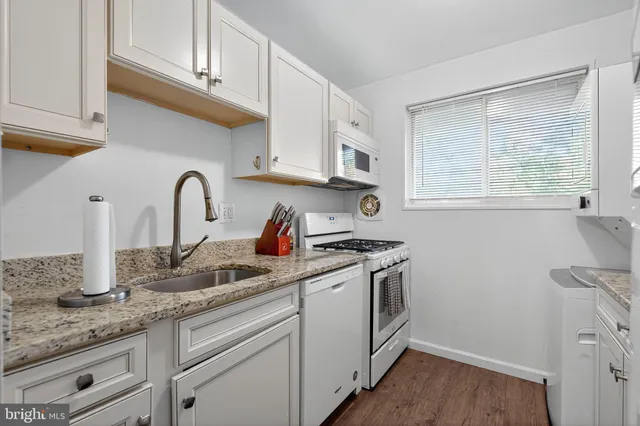 a kitchen with stainless steel appliances granite countertop a sink a stove and cabinets