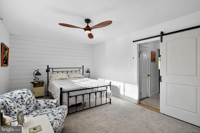 a bedroom with a bed and a ceiling fan