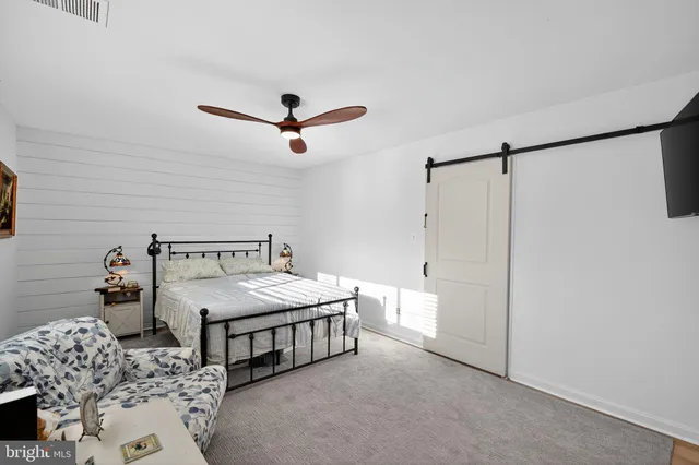 a bedroom with a bed next to a window with a chandelier