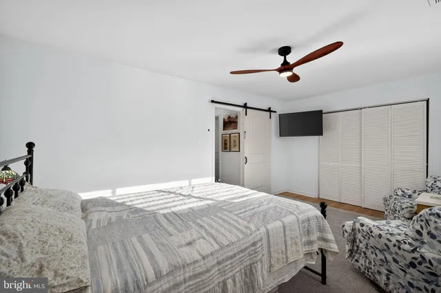 a bedroom with a bed and a ceiling fan