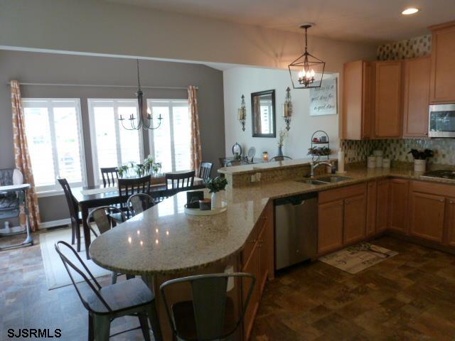 218 Surf Road Egg Harbor Township, NJ 08234 - Photo 6 of 28 a kitchen with sink dining table and chairs