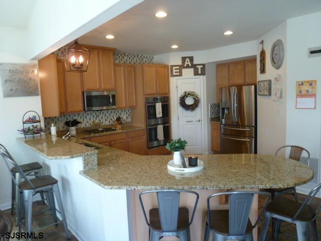 218 Surf Road Egg Harbor Township, NJ 08234 - Photo 10 of 28 a kitchen with granite countertop kitchen island stainless steel appliances a refrigerator a sink a stove a dining table and chairs