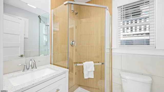 a bathroom with a granite countertop sink a mirror and a shower