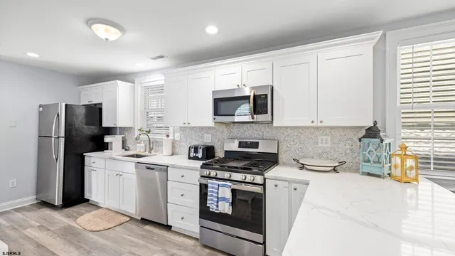 a kitchen with white cabinets and stainless steel appliances