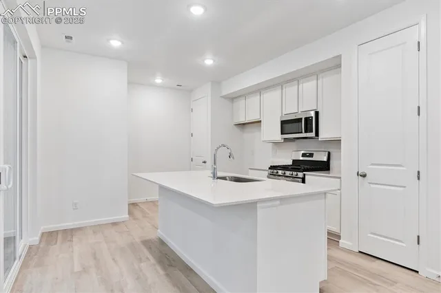 a kitchen with appliances a sink and cabinets