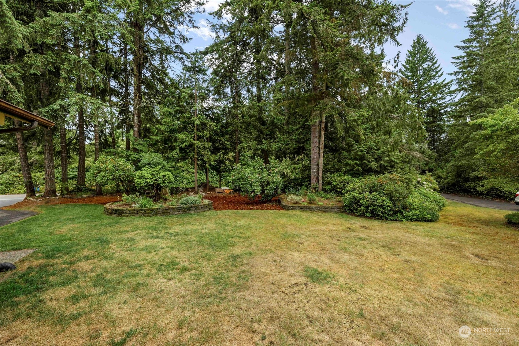 3156 Locker Road Southeast Port Orchard, WA 98366 - Photo 27 of 35 a backyard of a house with plants and large trees