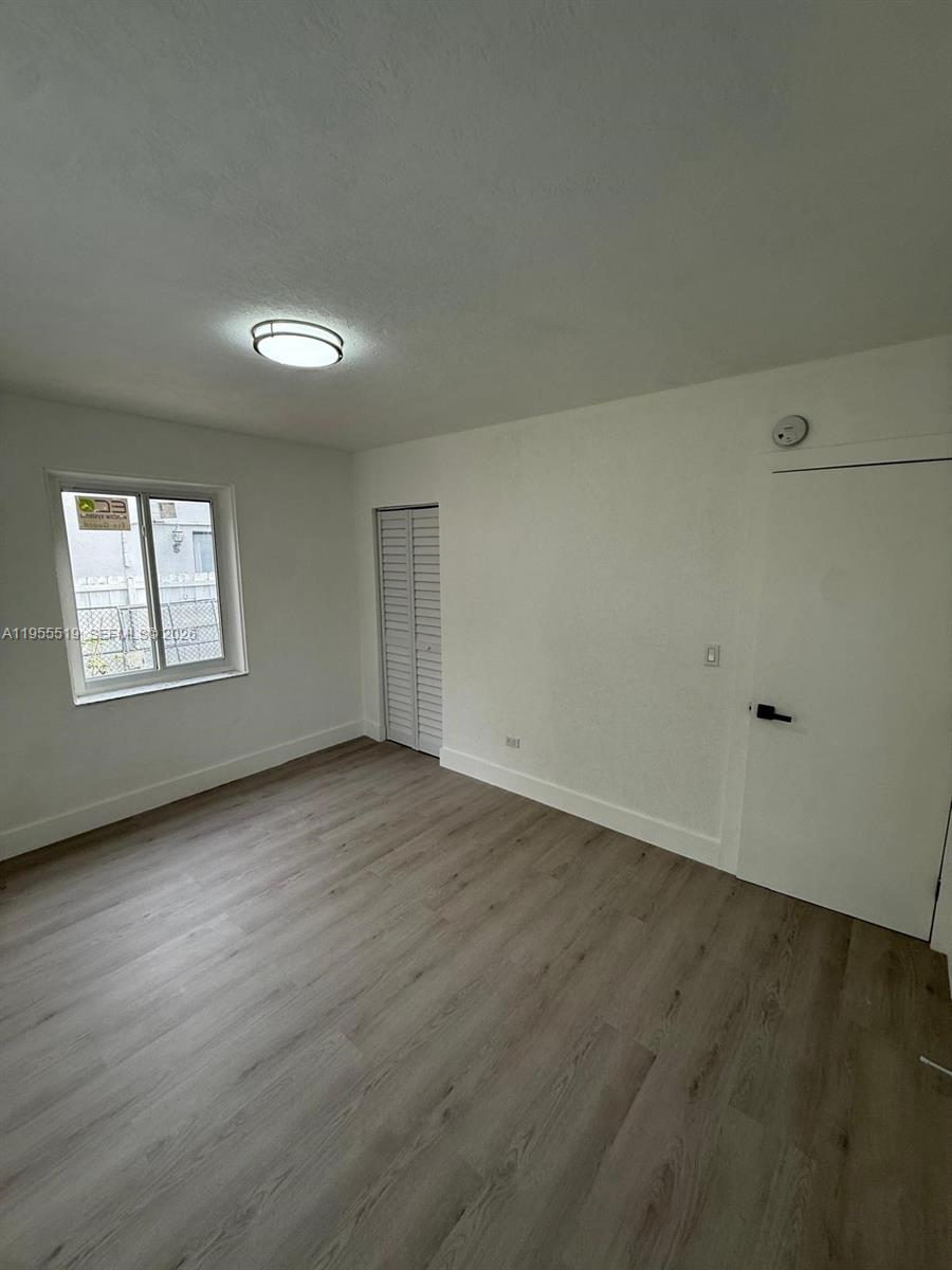 4366 Southwest 5th Terrace Miami, FL 33134 - Photo 21 of 30 an empty room with wooden floor and windows