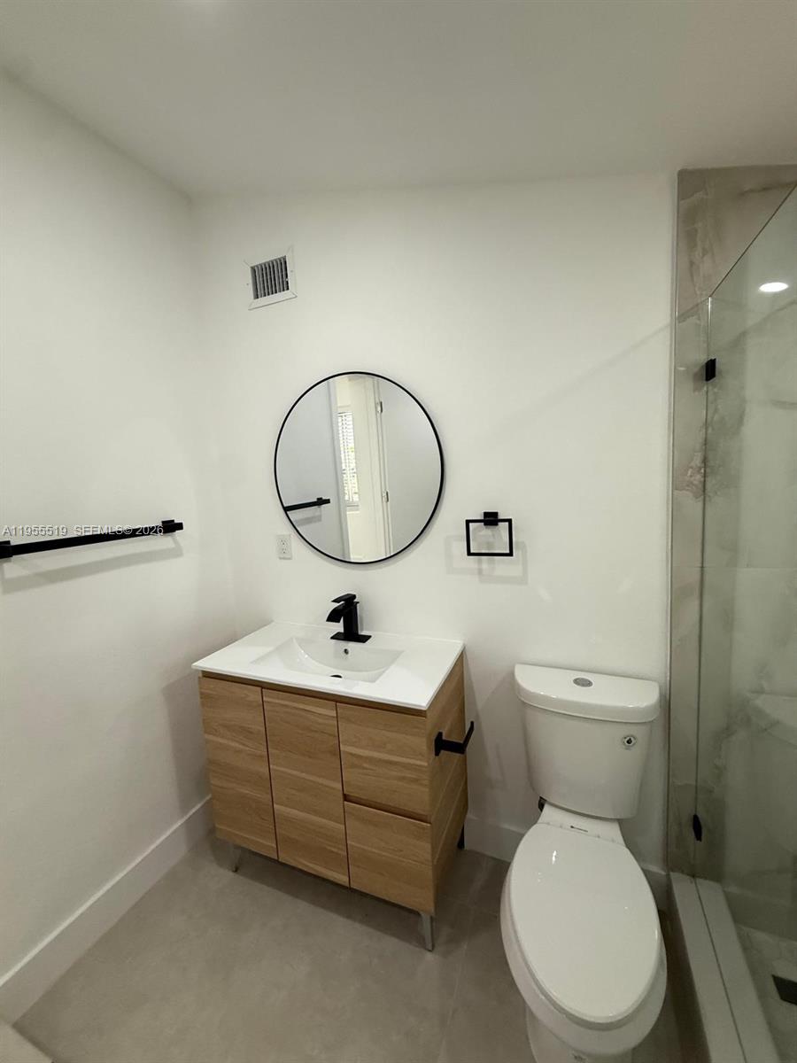 4366 Southwest 5th Terrace Miami, FL 33134 - Photo 25 of 30 a bathroom with a toilet a sink and a mirror