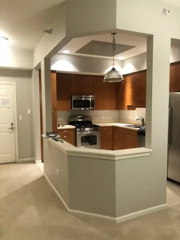 a kitchen with stainless steel appliances granite countertop a sink a stove and a refrigerator