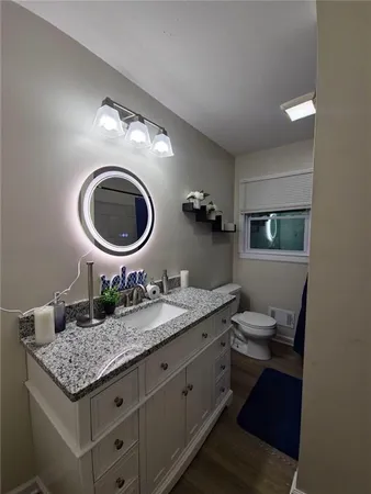 a bathroom with a granite countertop sink and a mirror