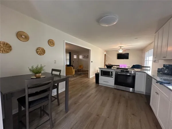 a kitchen with stainless steel appliances a stove a sink a microwave a refrigerator and cabinets