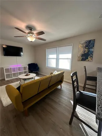 a living room with furniture a flat screen tv and a window